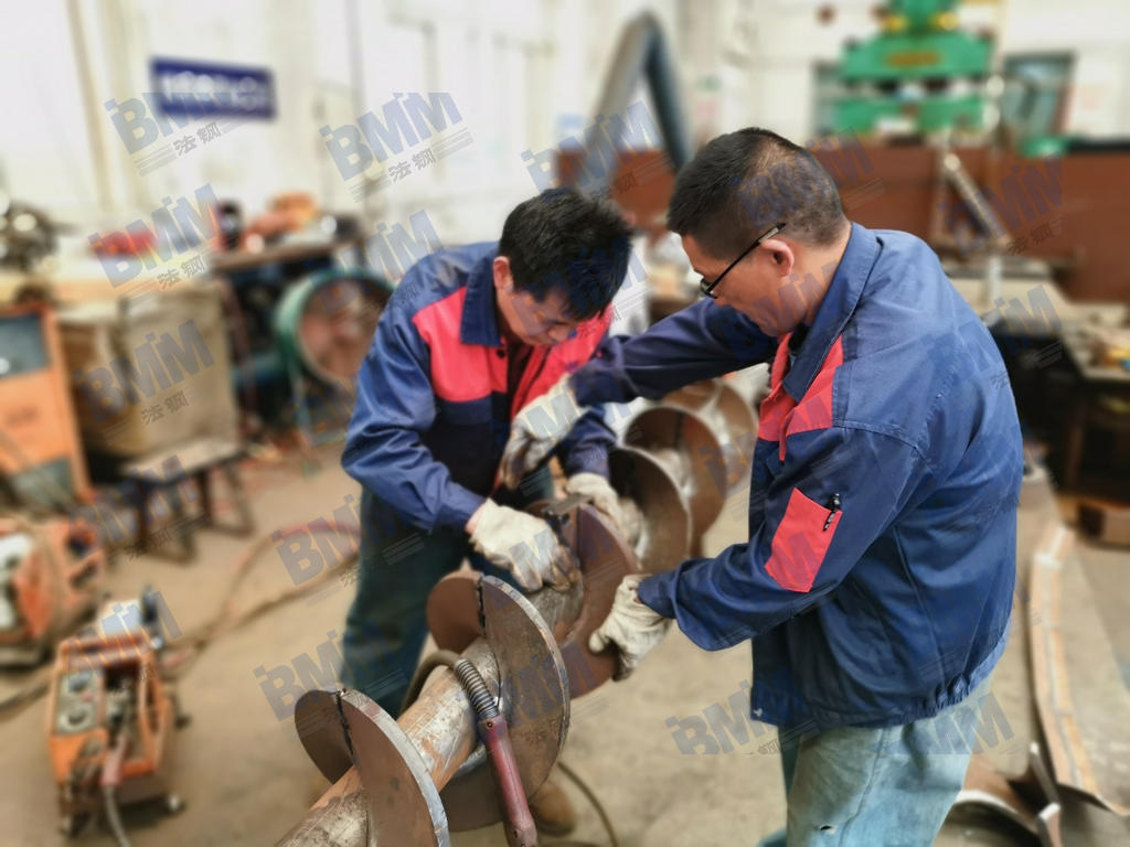 710公海技术人员正在对耐磨螺旋输送部件进行组装和焊接